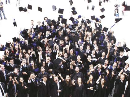 Étudiants ingénieurs diplômés lançant leurx chapeaux universitaires