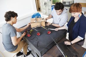 3 étudiants fabriquant un robot hexapode