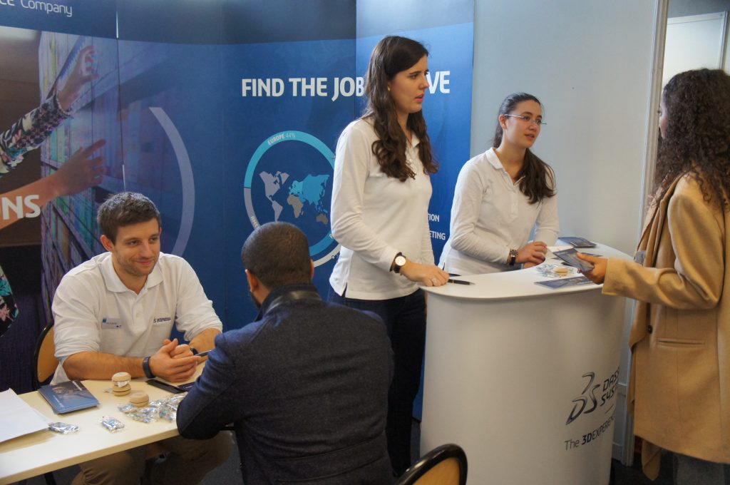 Photo d'un stand au forum entreprise ENSEA Supméca, des professionnels hommes et femmes font face à des étudiants