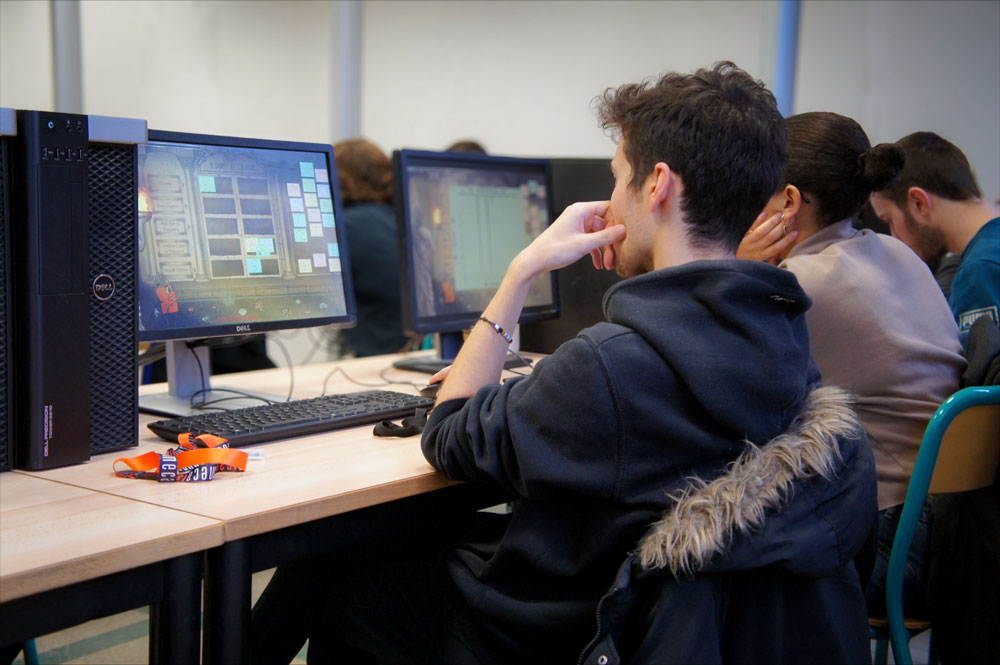 Une classe d'étudiants ingénieurs jouent à un jeu vidéo pédagogique sur ordinateur